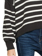 Close-up detail of Zenana Striped Sweater showing exposed seam along sleeve, ribbed cuff, and ribbed hem in black and white stripe kn