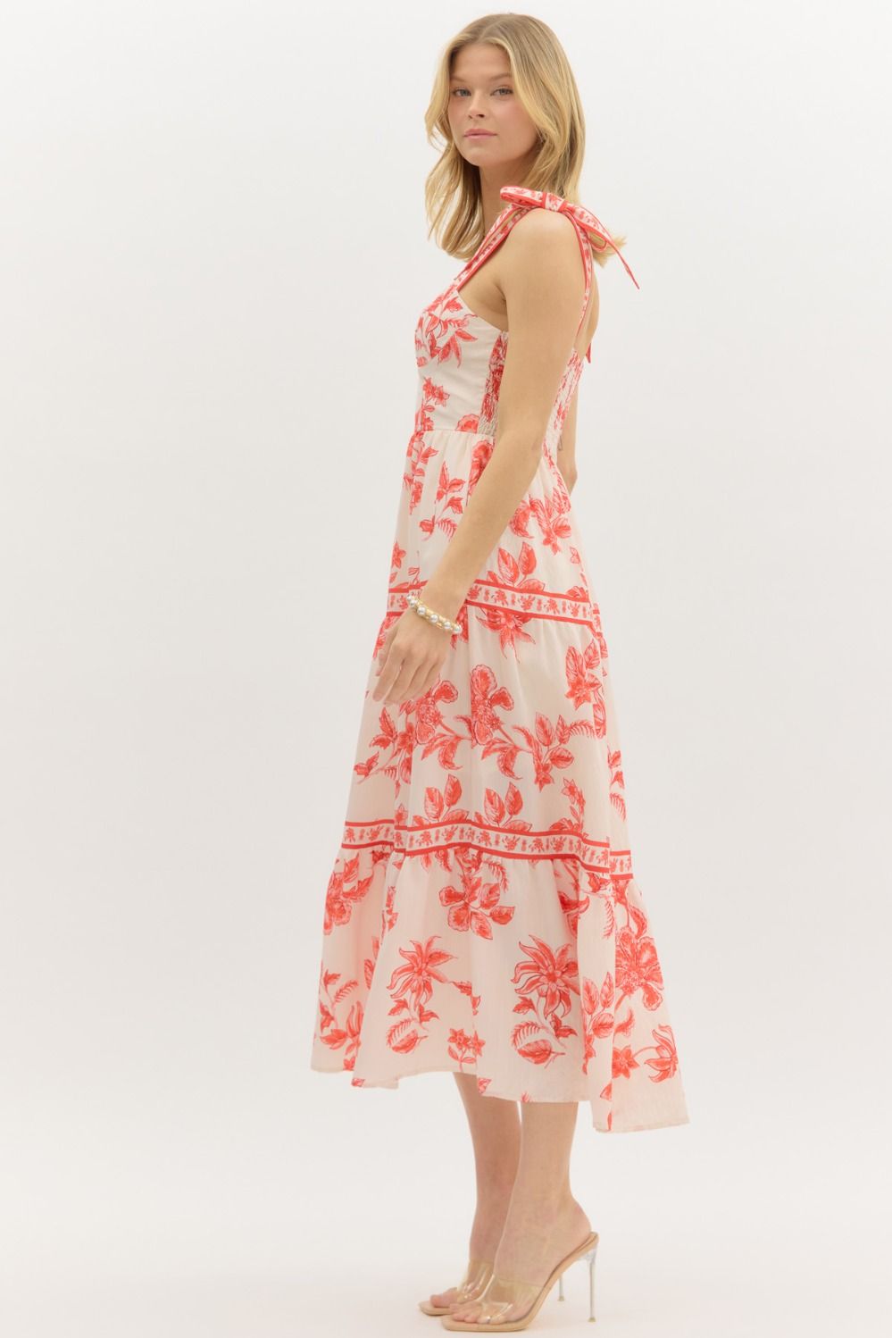 Model wearing a cream and burnt orange floral tiered maxi dress with tie straps, lined with hidden side pockets – Sunset Soirée Maxi