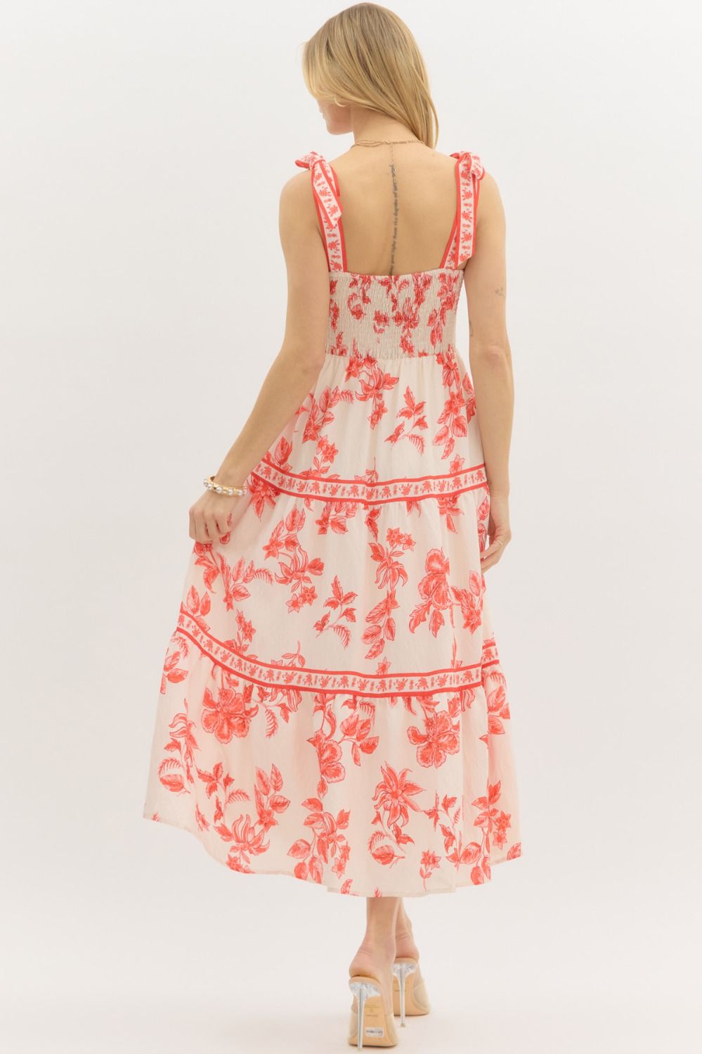 Model wearing a cream and burnt orange floral tiered maxi dress with tie straps, lined with hidden side pockets – Sunset Soirée Maxi