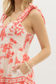 Model wearing a cream and burnt orange floral tiered maxi dress with tie straps, lined with hidden side pockets – Sunset Soirée Maxi