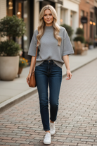 Heather grey mock neck boxy knit sweater top styled with dark wash straight leg jeans and white sneakers, candid outdoor lifestyle photo, women's boutique top at Thread Bar Boutique
