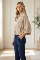 Taupe utility jacket with 3/4 button-tab sleeves, side pockets and a gathered elastic hem.