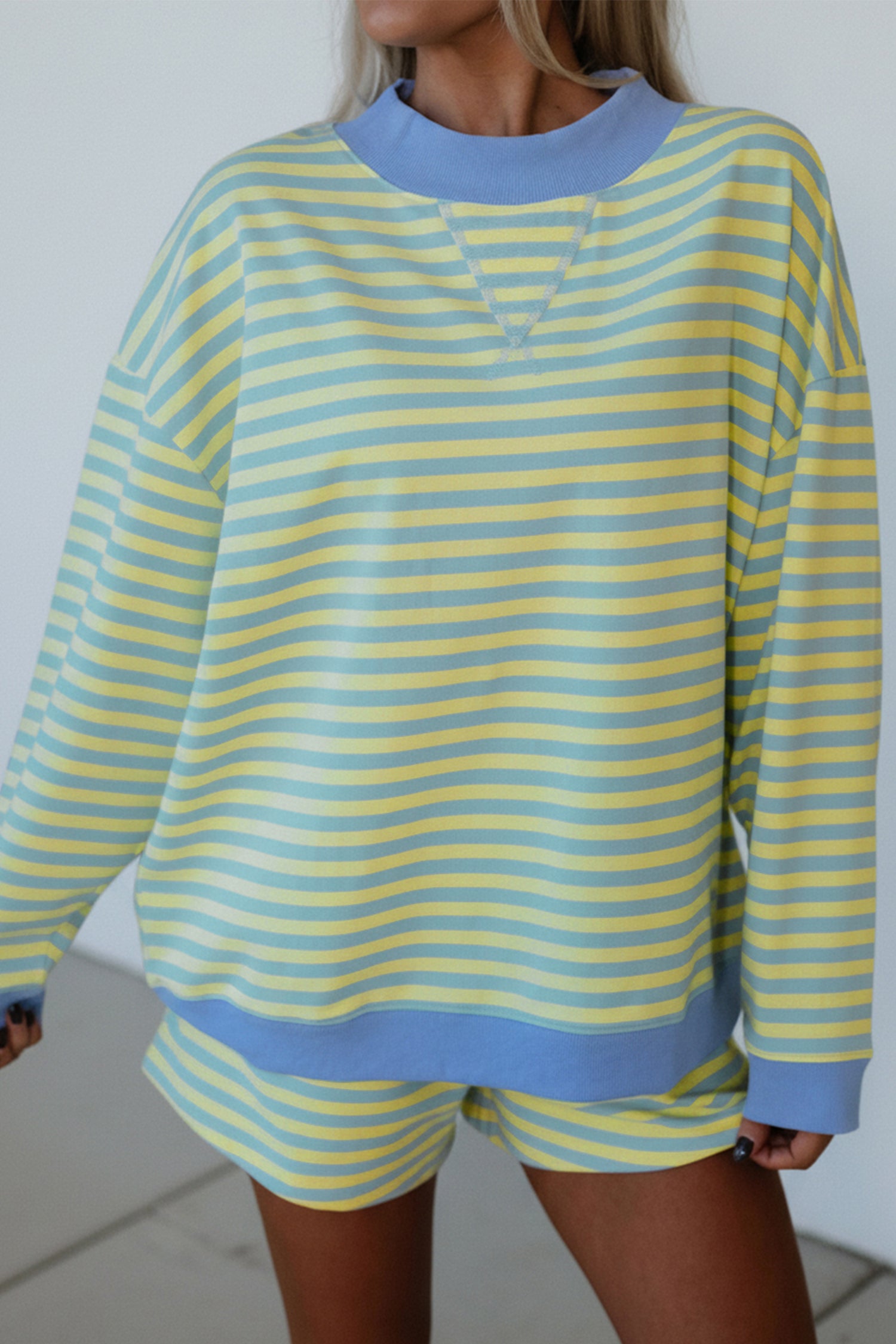yellow and blue striped mock neck pullover and shorts matching set for women, trendy stripe two piece lounge outfit with color block trim, women’s striped matching set featuring mock neck top and loose fit shorts, casual boutique striped outfit set