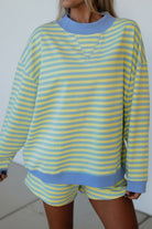 yellow and blue striped mock neck pullover and shorts matching set for women, trendy stripe two piece lounge outfit with color block trim, women’s striped matching set featuring mock neck top and loose fit shorts, casual boutique striped outfit set