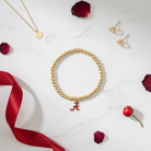 Alabama Crimson Tide Ball Bead Stretch Bracelet - flat lay on white marble with gold accents