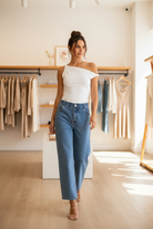 Asymmetrical off-shoulder top with rolled sleeve, form-fitting stretch fabric, and modern silhouette