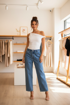 Chic asymmetrical top with off-shoulder neckline, rolled sleeve detail, and flattering fitted silhouette