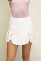 Butter soft faux leather tulip skort with bow tie detail and built-in shorts for women from Thread Bar Boutique