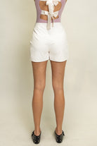 Butter soft faux leather tulip skort with bow tie detail and built-in shorts for women from Thread Bar Boutique