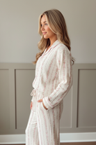Pink floral print long sleeve pajama shirt with notch collar and button front detail, side profile view showing relaxed silhouette and full-length pant