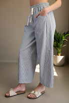 Three-quarter angle view of women's barrel pants — curved seam panel on thigh, wide leg silhouette, flattering fit through hip