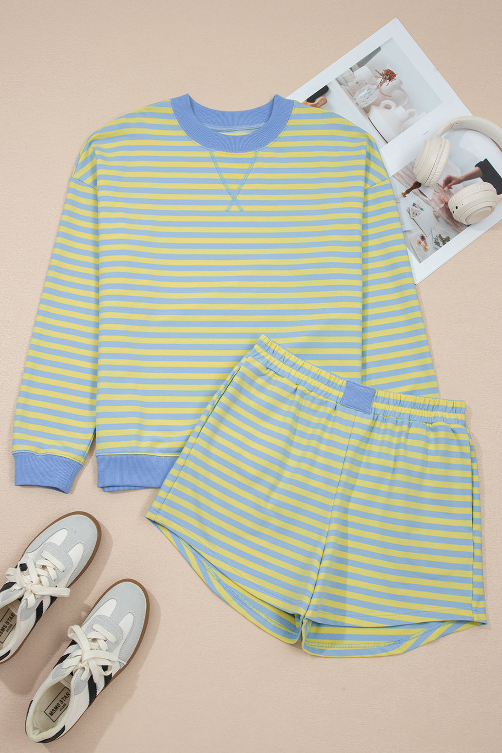 Yellow and blue striped long-sleeve shirt and shorts set with sneakers on a beige background