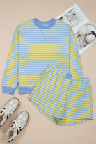 Yellow and blue striped long-sleeve shirt and shorts set with sneakers on a beige background