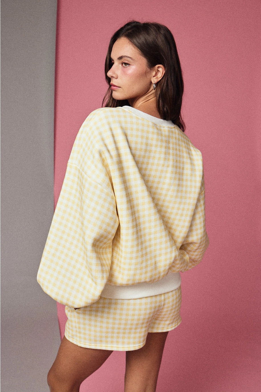Yellow and white gingham cozy chic women’s lounge set featuring a plush crewneck sweatshirt and drawstring shorts with pockets side view