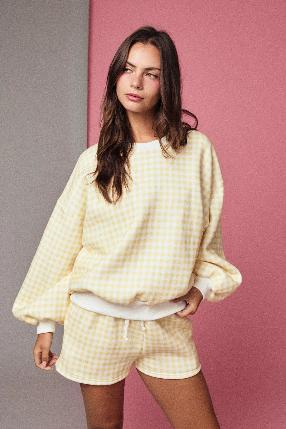 Yellow and white gingham cozy chic women’s lounge set featuring a plush crewneck sweatshirt and drawstring shorts with pockets front view